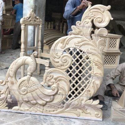 A carved peacock panel with a jali lattice cutout
