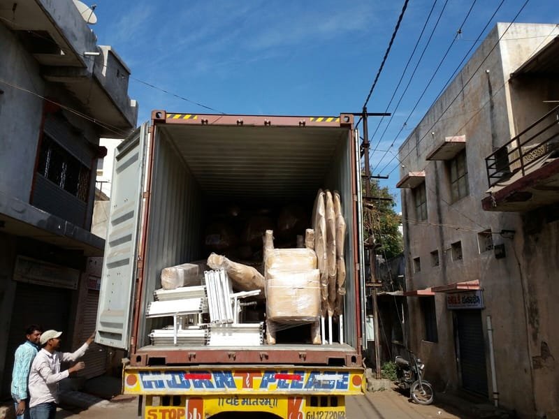 Wrapped furniture and mandap parts loaded into a shipping container