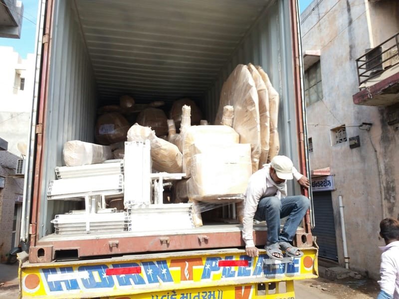 Our team loading wrapped furniture into a container