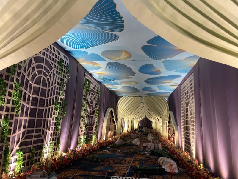 Lattice panels, sculpted arches and a printed canopy installed as a wedding entrance corridor